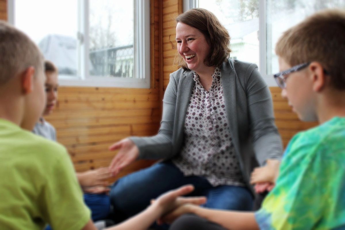 A behavior analyst leading a group session with children