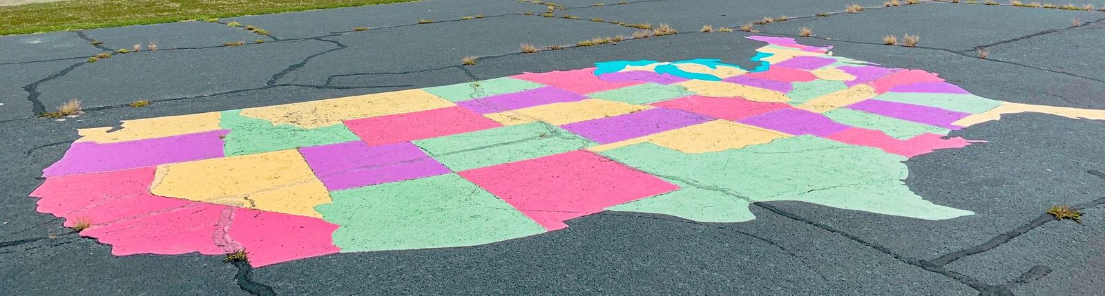 A colorful chalk drawing of a map of the United States on pavement